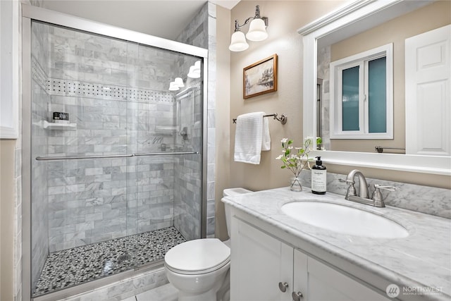 full bath with vanity, a shower stall, and toilet