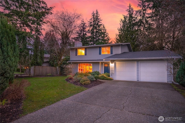 traditional-style house featuring fence, concrete driveway, a chimney, a yard, and an attached garage