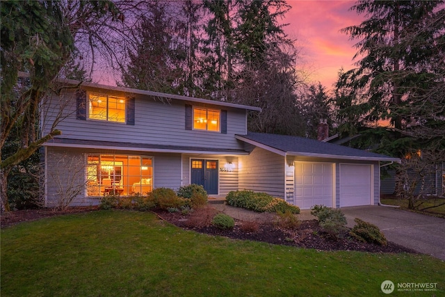 traditional-style home featuring a yard, a garage, and driveway