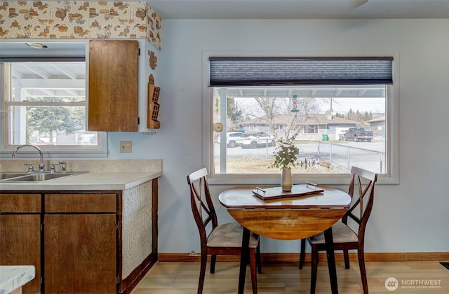 dining space featuring light wood-type flooring and baseboards