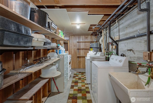 laundry area featuring a sink, washing machine and dryer, gas water heater, light floors, and laundry area