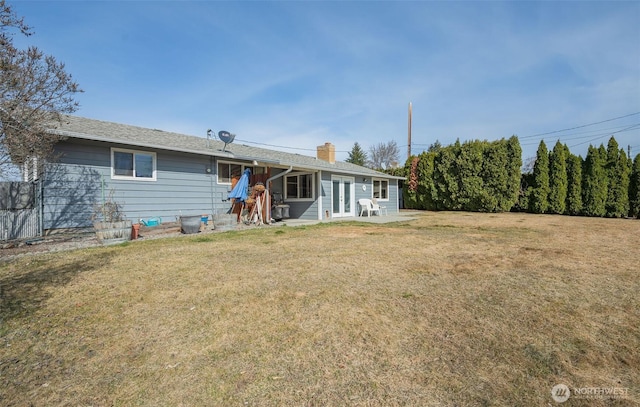 back of property featuring a patio area, a lawn, french doors, and a chimney