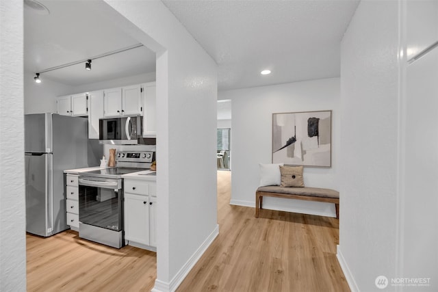 kitchen featuring white cabinetry, light wood-style floors, baseboards, and appliances with stainless steel finishes