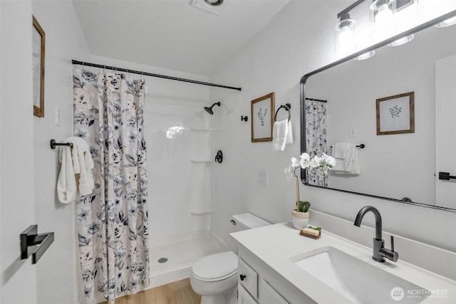 full bathroom with vanity, a shower stall, toilet, and wood finished floors