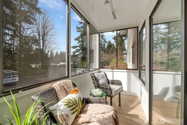 sunroom / solarium featuring plenty of natural light and rail lighting