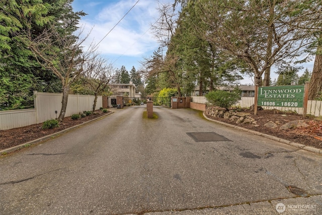 view of street featuring curbs, a gated entry, and a gate