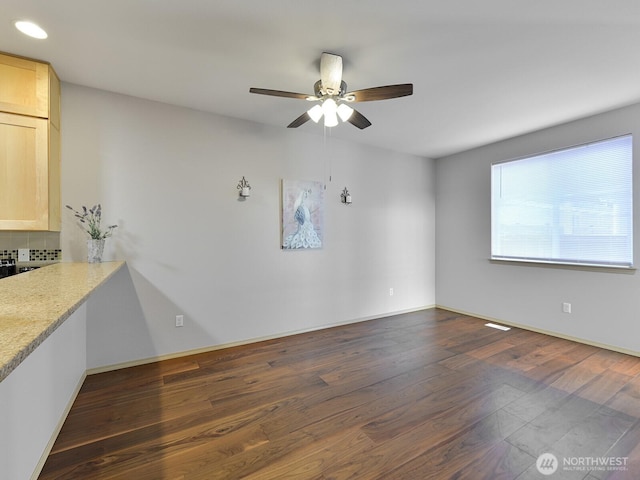 spare room featuring dark wood-type flooring, baseboards, and ceiling fan