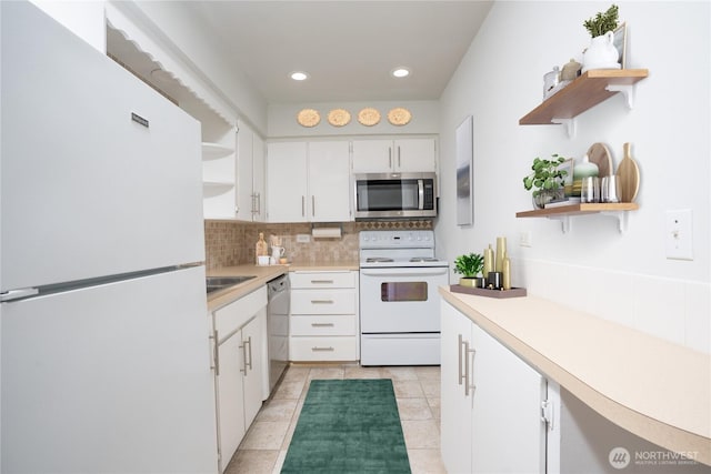 kitchen with light countertops, decorative backsplash, stainless steel appliances, white cabinetry, and open shelves