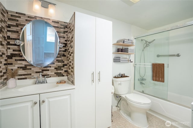 full bathroom featuring combined bath / shower with glass door, backsplash, toilet, and vanity