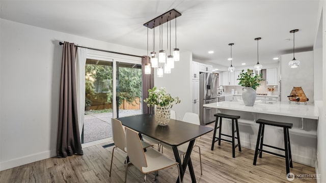 dining space featuring recessed lighting, light wood-type flooring, and baseboards