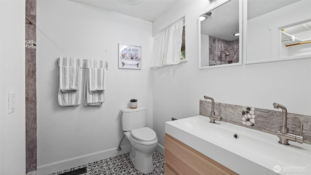 bathroom featuring toilet, tile patterned flooring, a shower, baseboards, and vanity