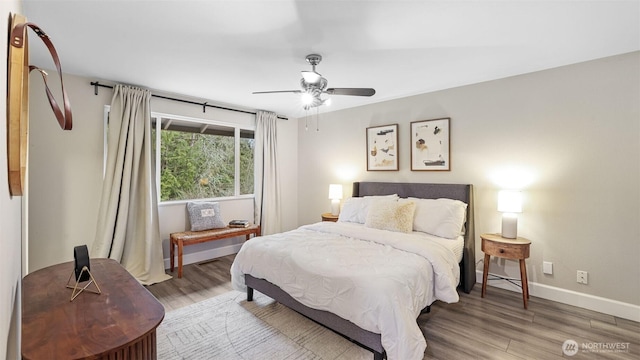 bedroom featuring ceiling fan, baseboards, and wood finished floors