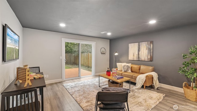 living room featuring recessed lighting, baseboards, and wood finished floors