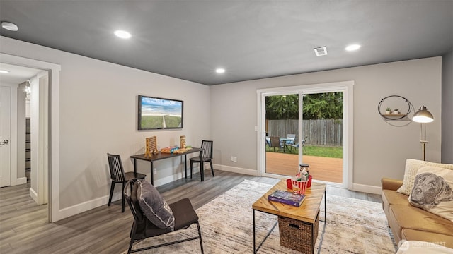 living room with recessed lighting, visible vents, and wood finished floors