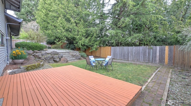 deck with a lawn and a fenced backyard