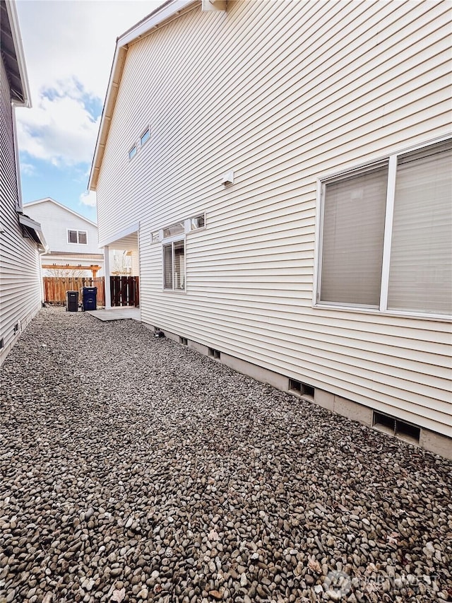 view of home's exterior with crawl space, a patio area, and fence