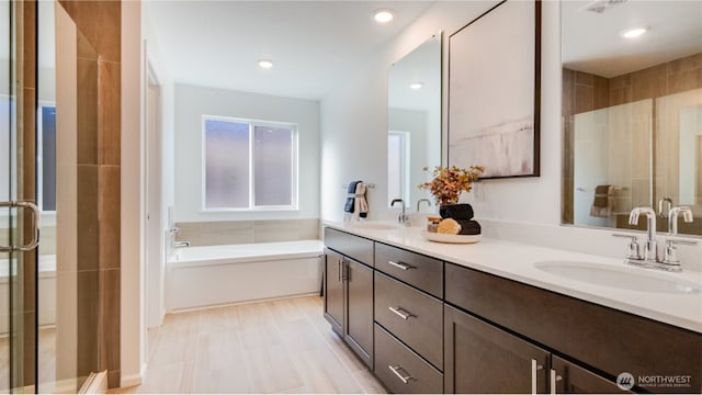 bathroom featuring a sink, a garden tub, and a stall shower