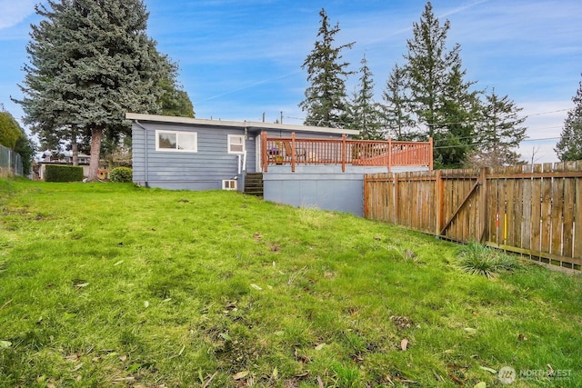 back of house featuring a yard, a deck, and fence