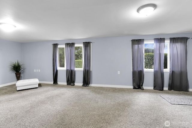 spare room with baseboards and carpet floors