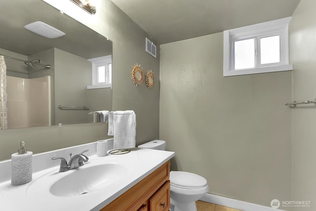 bathroom featuring vanity, a shower with shower curtain, baseboards, visible vents, and toilet