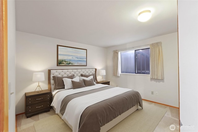 bedroom with baseboards and light carpet