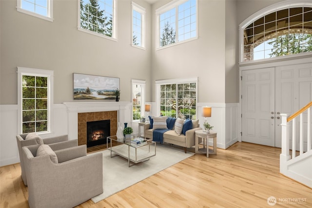 living area with stairway, plenty of natural light, and wood finished floors