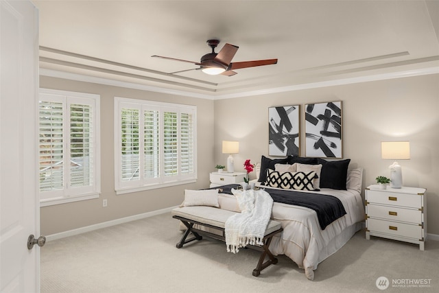 bedroom with a raised ceiling, light carpet, baseboards, and ornamental molding