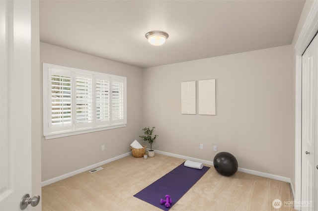 exercise area featuring visible vents, baseboards, and carpet