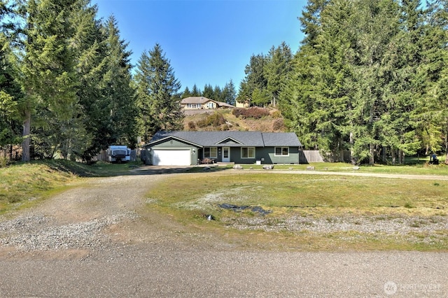 ranch-style house featuring driveway, an attached garage, and a front lawn