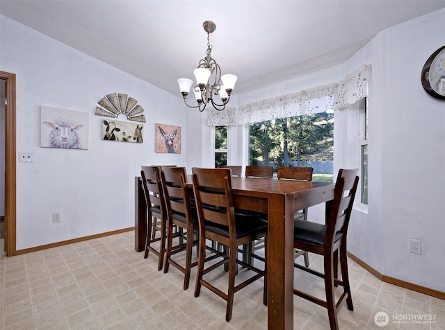 dining space with a notable chandelier and baseboards