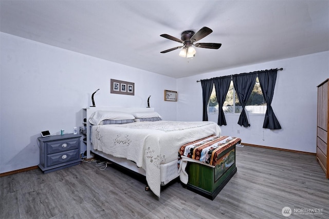 bedroom featuring baseboards, ceiling fan, and wood finished floors