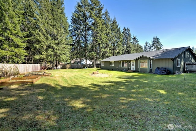 view of yard featuring a vegetable garden and fence