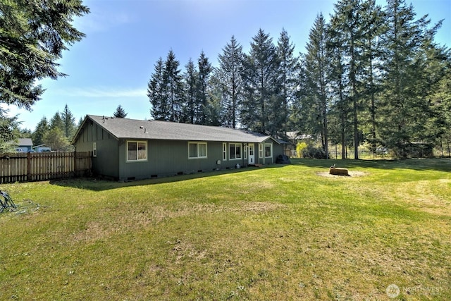 back of house featuring crawl space, a yard, and fence