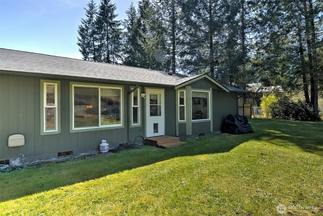 exterior space featuring crawl space, a yard, and roof with shingles