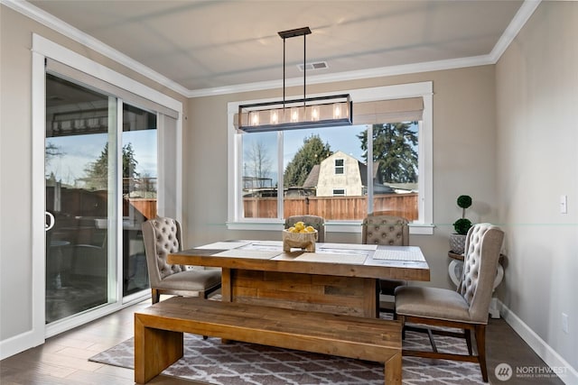 dining space with visible vents, crown molding, baseboards, and wood finished floors