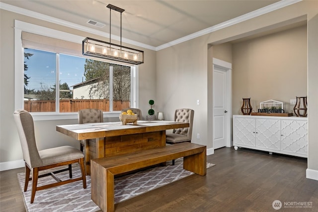 dining area with baseboards, wood finished floors, visible vents, and ornamental molding