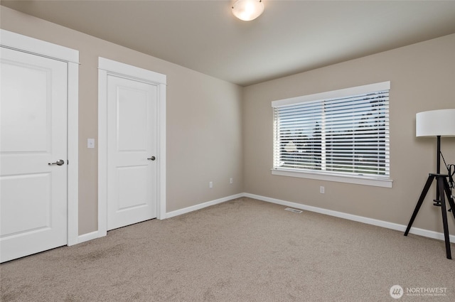 unfurnished bedroom featuring carpet flooring, baseboards, and visible vents