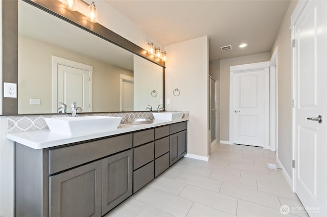 full bathroom featuring a shower stall, double vanity, visible vents, and a sink