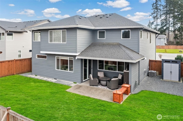 rear view of property with a patio, a yard, a fenced backyard, central AC, and a shingled roof