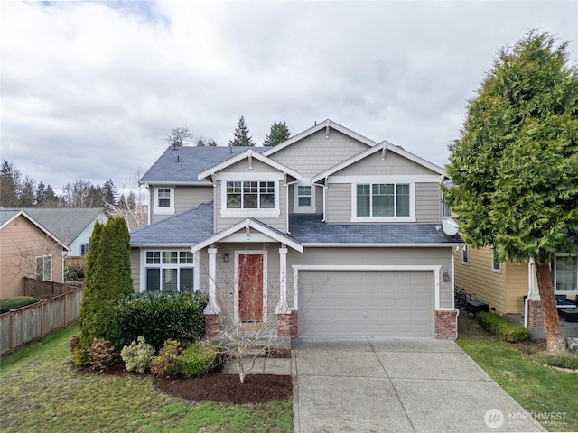 craftsman inspired home with brick siding, an attached garage, concrete driveway, and fence