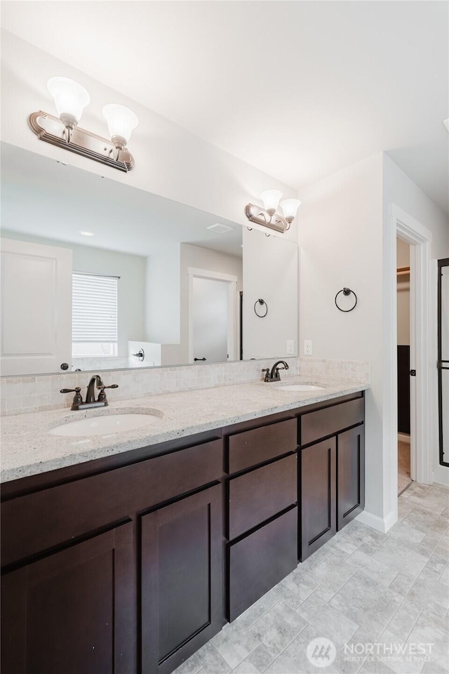 bathroom featuring double vanity, a chandelier, and a sink