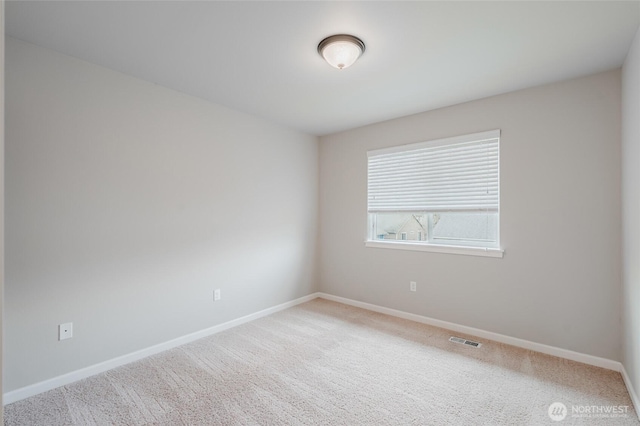 spare room with visible vents, baseboards, and carpet flooring