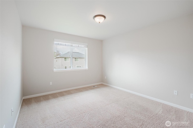 spare room with baseboards, carpet floors, and visible vents