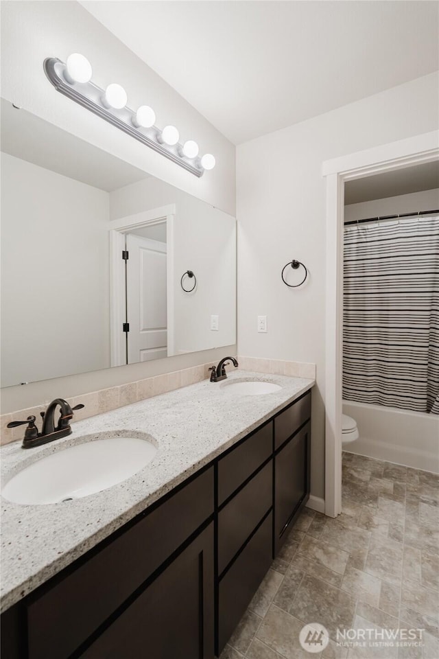 bathroom with double vanity, toilet, shower / tub combo with curtain, and a sink