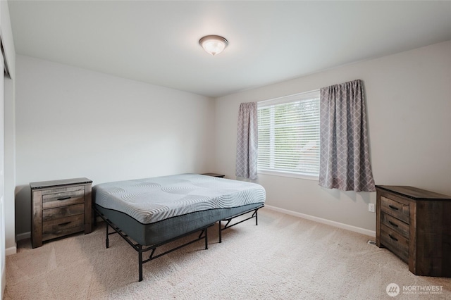 bedroom with baseboards and light colored carpet