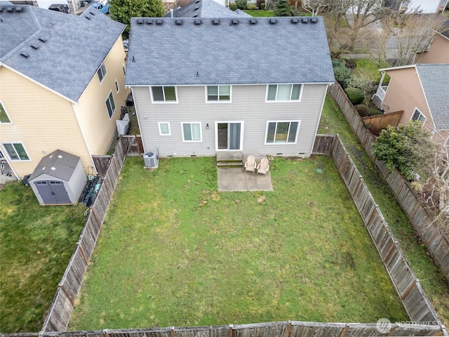 back of property with a shed, a patio area, central air condition unit, a yard, and an outbuilding