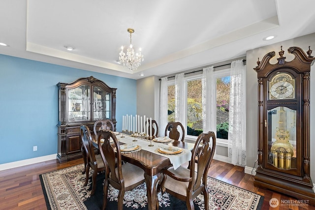 dining room with baseboards, recessed lighting, a notable chandelier, a raised ceiling, and dark wood-style flooring