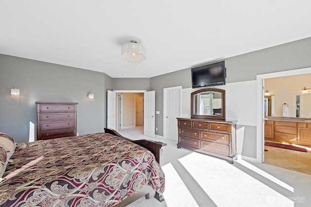 bedroom featuring connected bathroom, baseboards, and light carpet