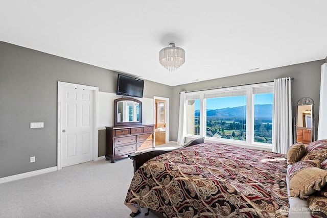 carpeted bedroom with baseboards and an inviting chandelier