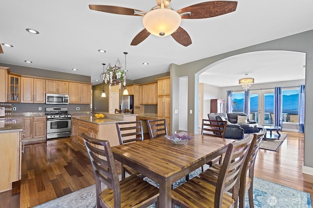 dining space featuring recessed lighting, arched walkways, dark wood finished floors, and ceiling fan